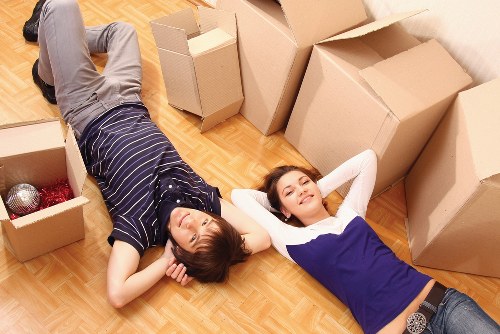 Professional movers carrying household items through a Docklands apartment entrance
